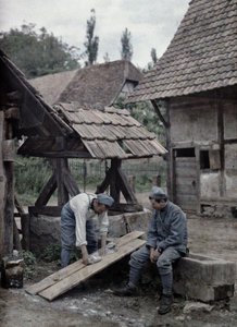フランスの2人の兵士が1917年6月21日、フランス、アルザス地方、オートラン県ギルドヴィレールの町の農家近くの噴水の谷に設置されたボードを使って洗濯物を世話している（a 作： Paul Castelnau